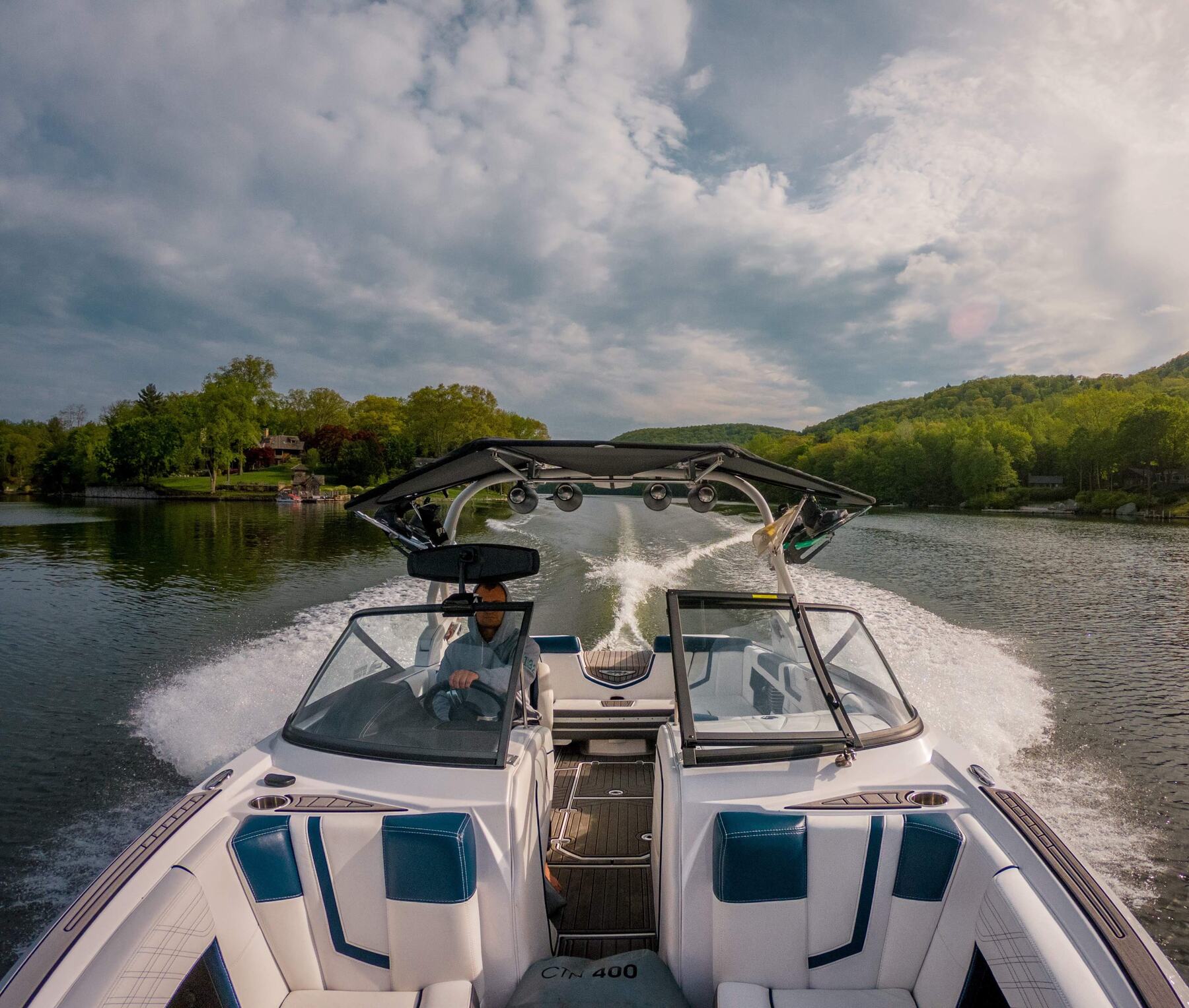 Boat on Candlewood Lake with waterfront homes in the background